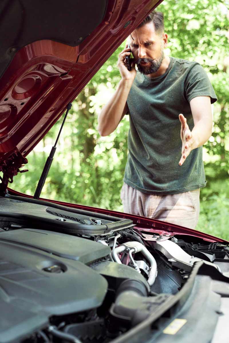 Junger Mann prüft Getriebeschaden bei Schrottauto Ankauf Norderstedt